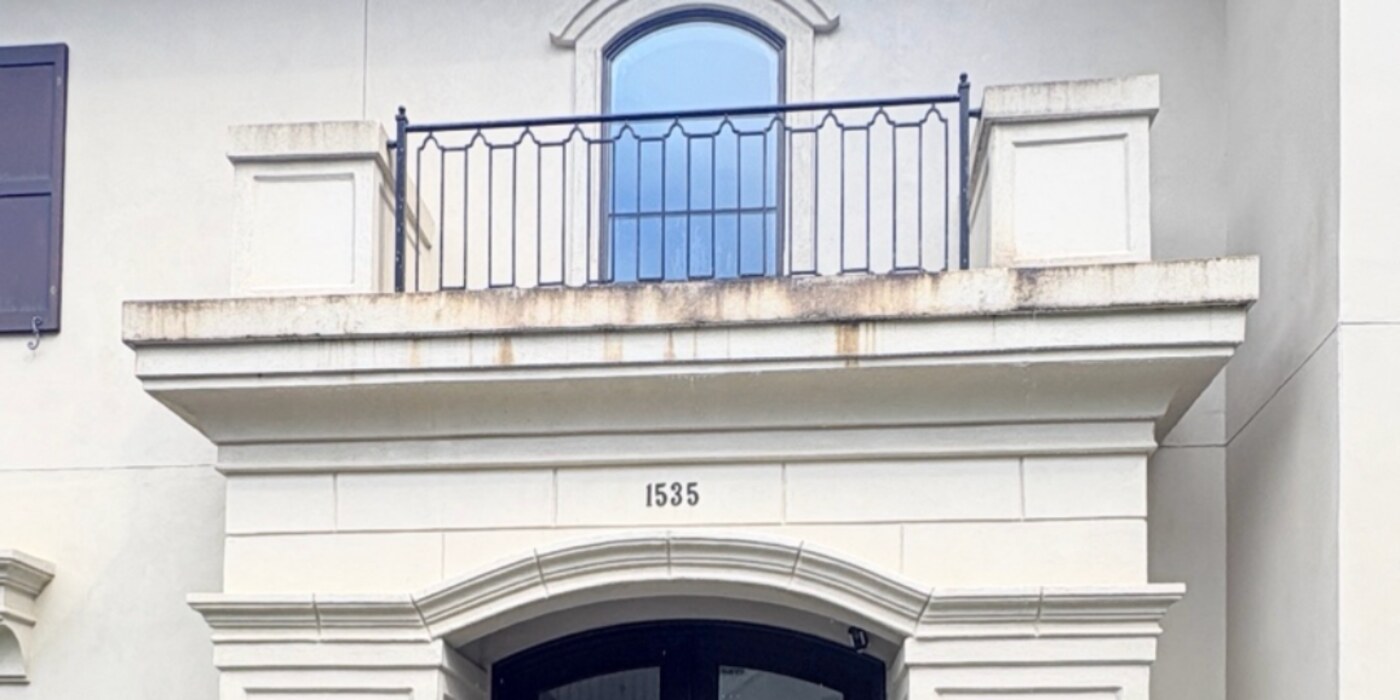 Stucco and cast stone entry before and after an exterior cleaning — before