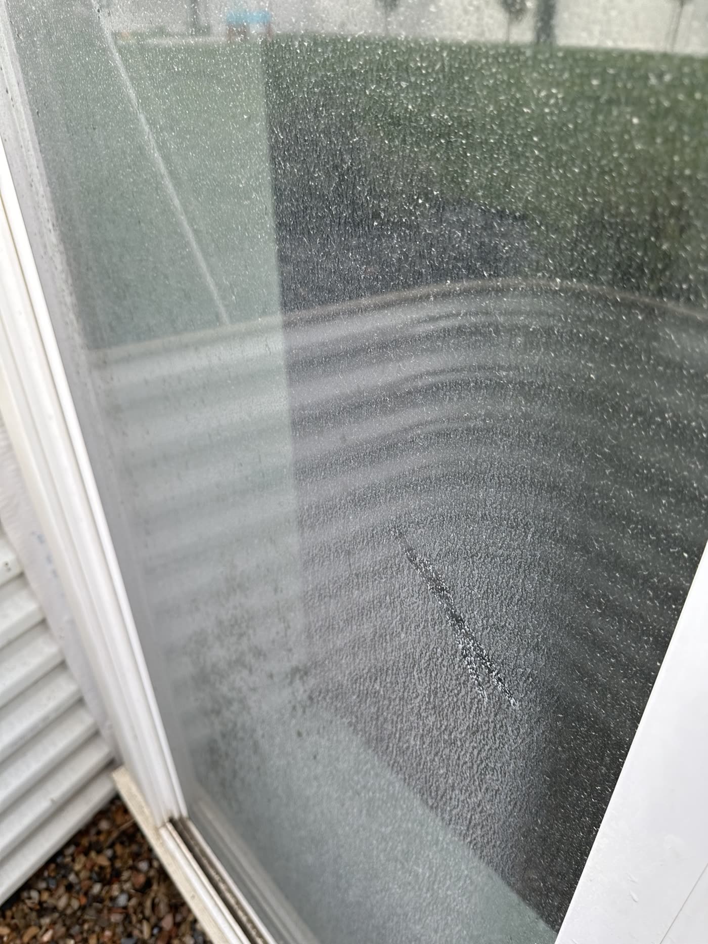 Exterior window glass covered in dirt and water spotting before cleaning, and the same clear glass afterward — before