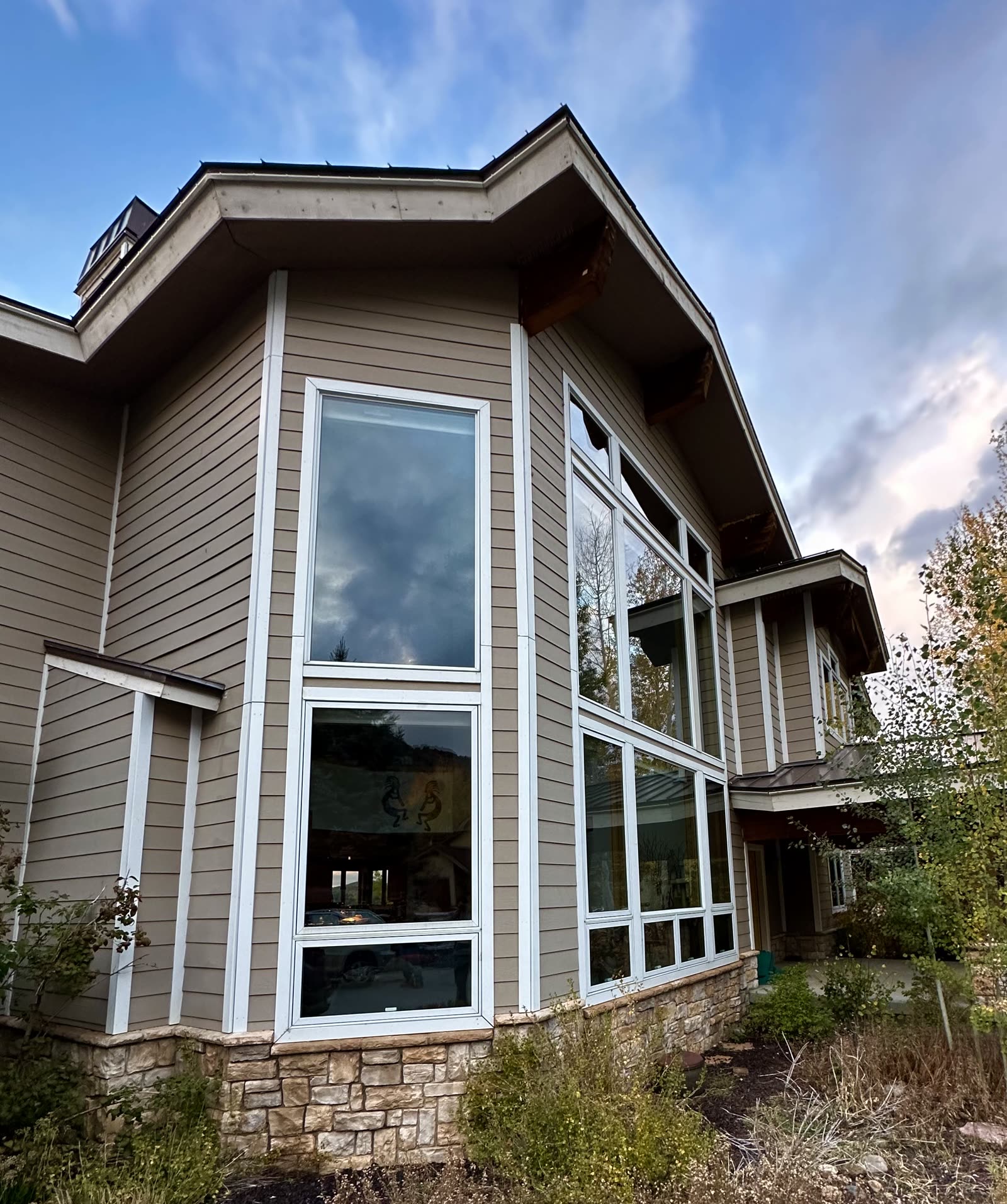Tall clean exterior windows on a two-story home at dusk