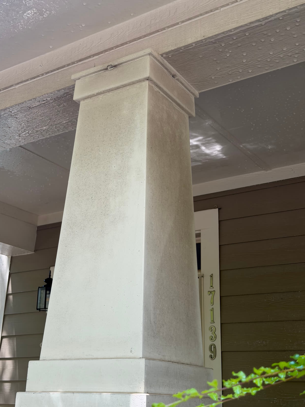 Dirt-stained porch column before and after cleaning — before